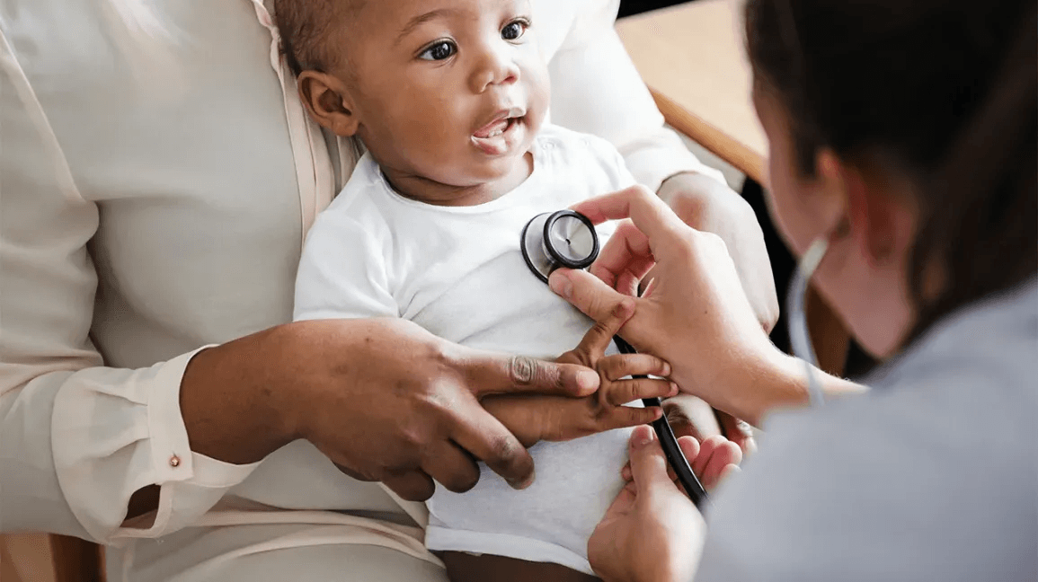 A clinician listening to a baby with a stethoscope.
